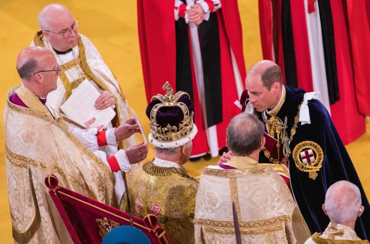 The Prince of Wales kneels before his father, King Charles III, during the king's coronation ceremony inside Westminster Abbey on Saturday.