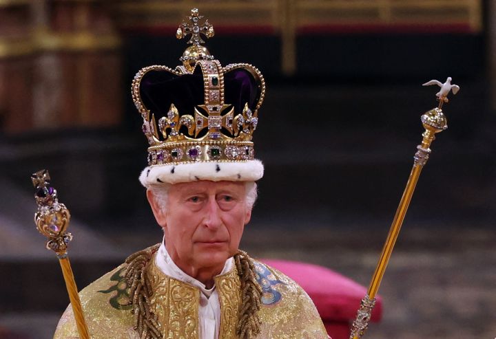 Charles, wearing the St. Edward's Crown and holding the Sovereign's Sceptre with Dove (right) and Sovereign's Sceptre with Cross, is seen during the coronation ceremony.